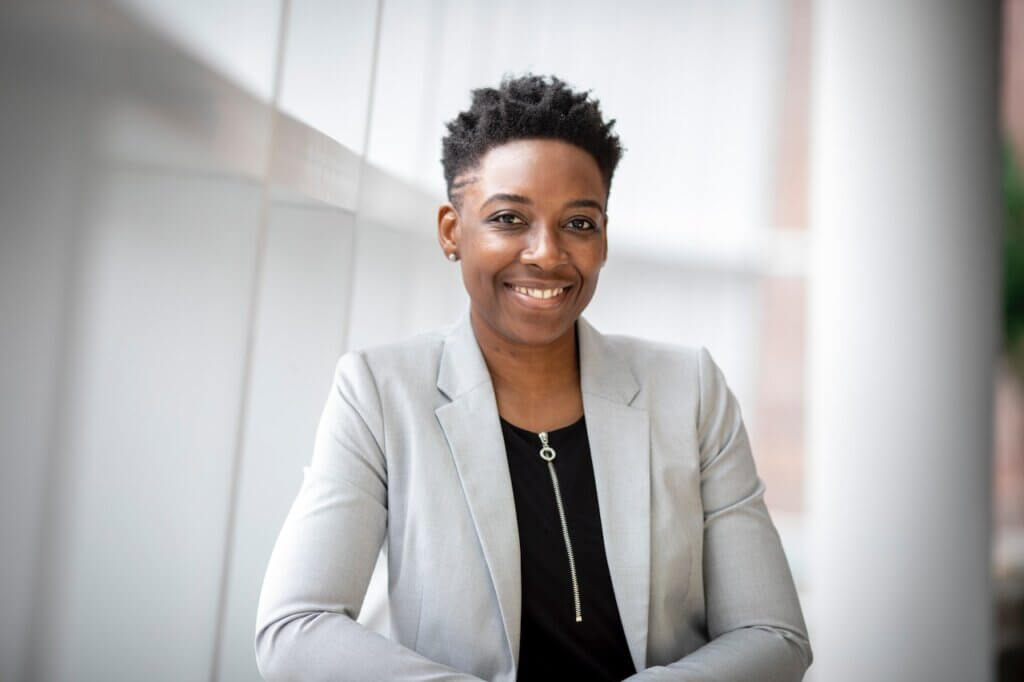 A black woman smiling in an office environment - strategy and Operations
