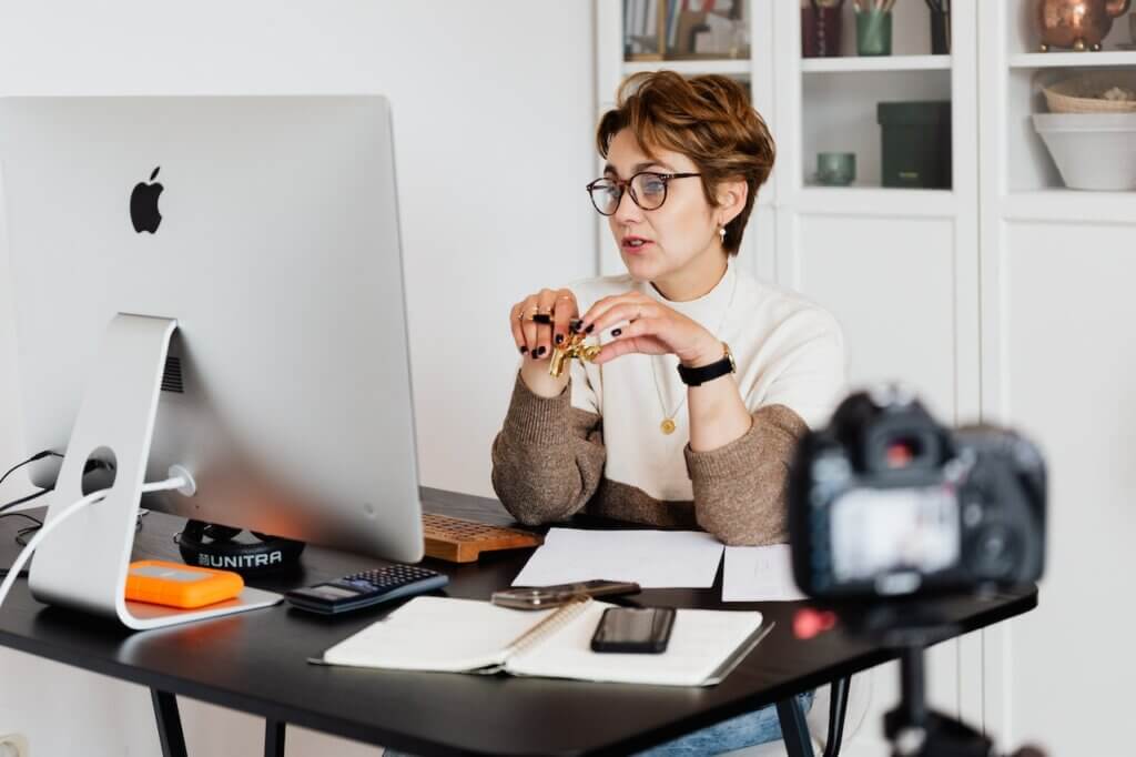 A woman sitting in front of a desktop - Interior Design Tutor