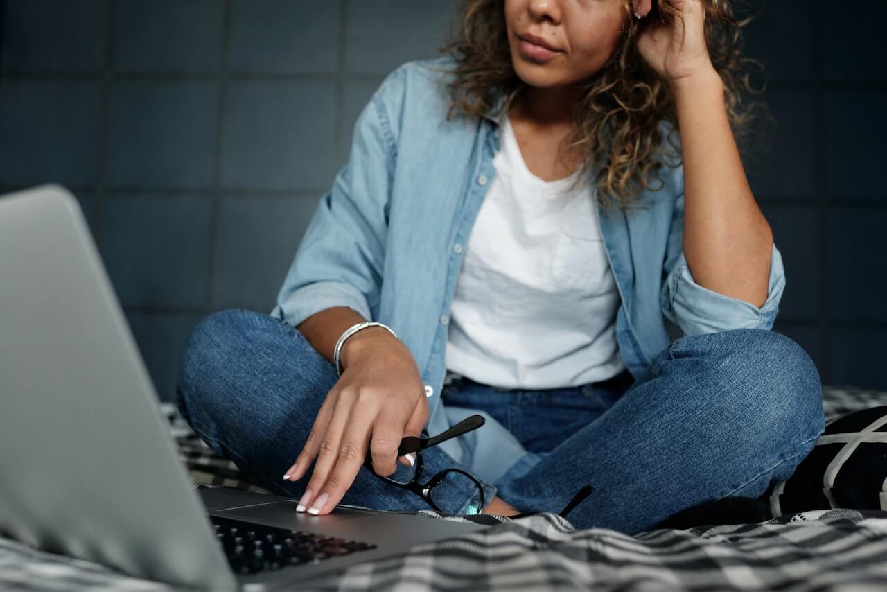 A lady sitting on a bed with a laptop - social media marketing