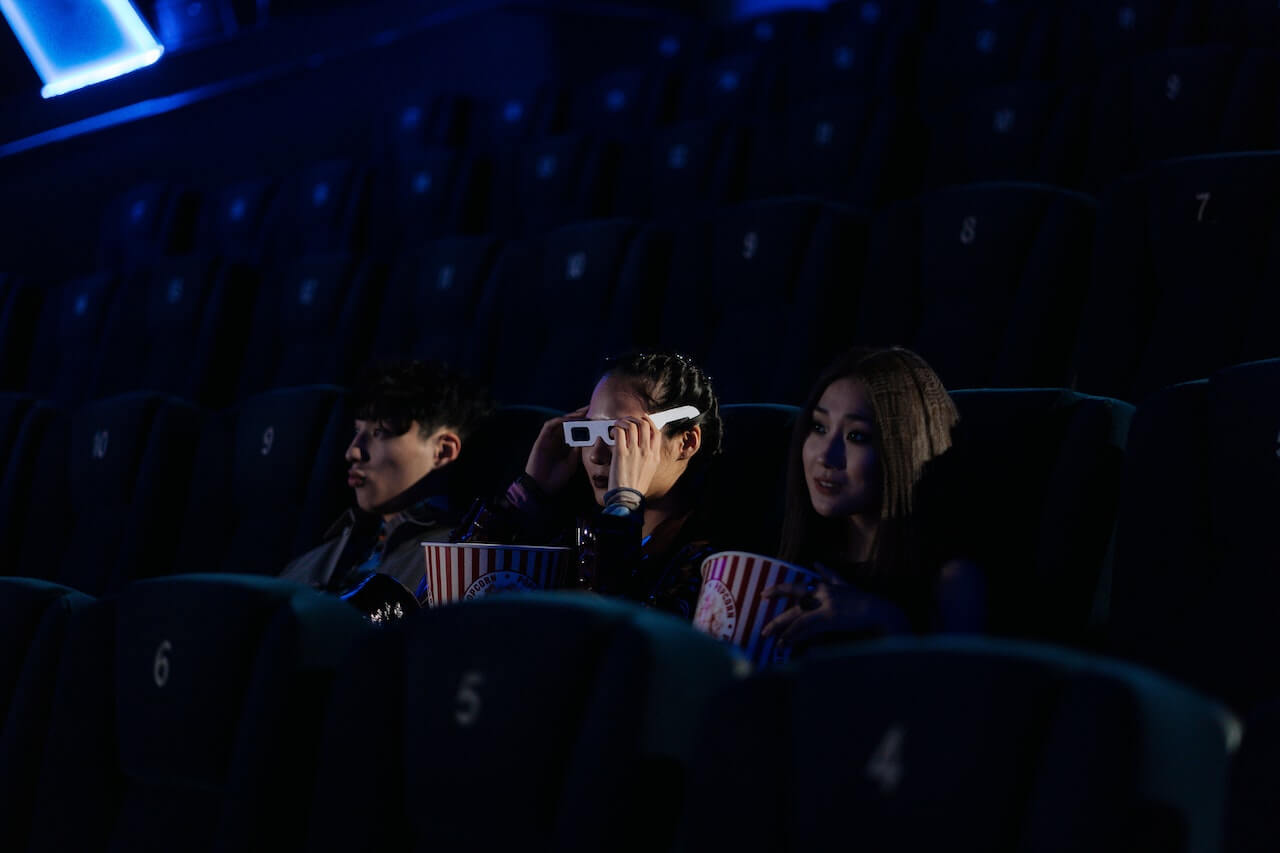 3 individuals in a cinema seeing the work of filmmakers