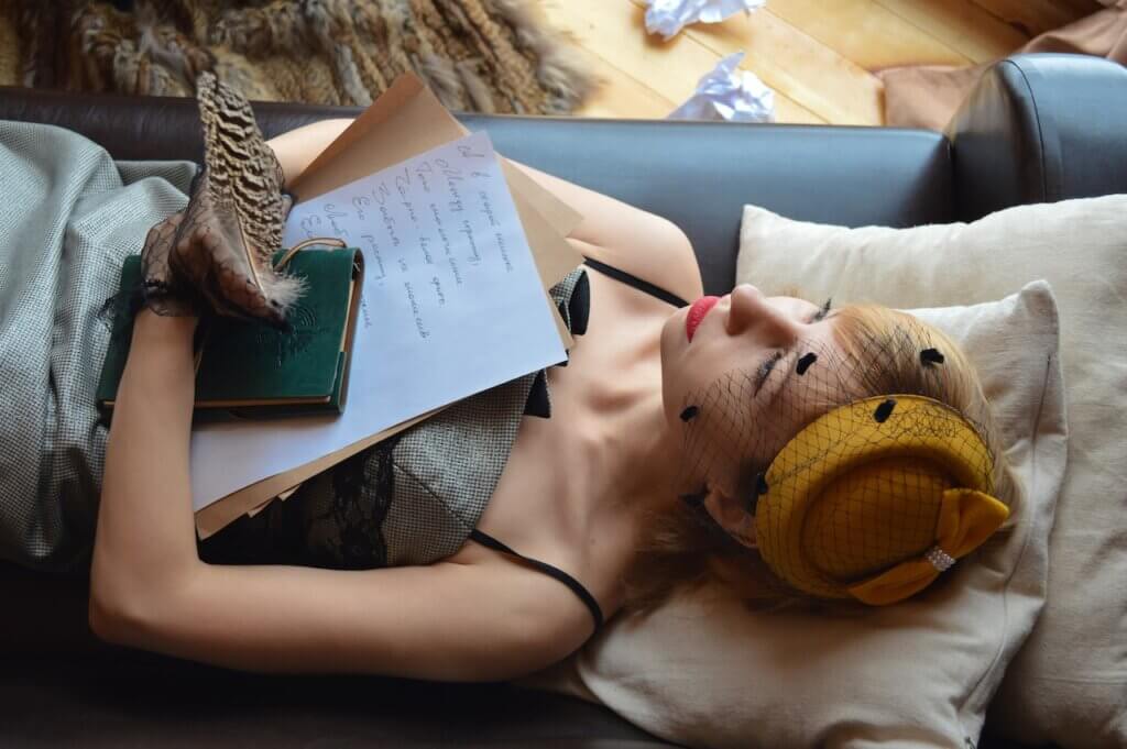 A lady lying down with a notepad and pen